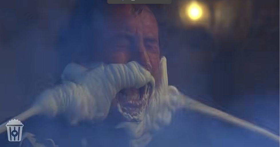 Dibs strapped into an automated grooming machine, a mechanical toothbrush pressed against his face
