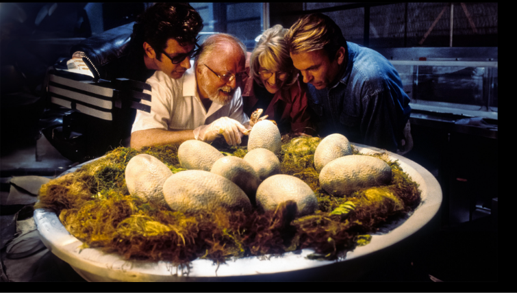 Scientists leaning over a nest of hatching dinosaur eggs in a Jurassic Park hatchery